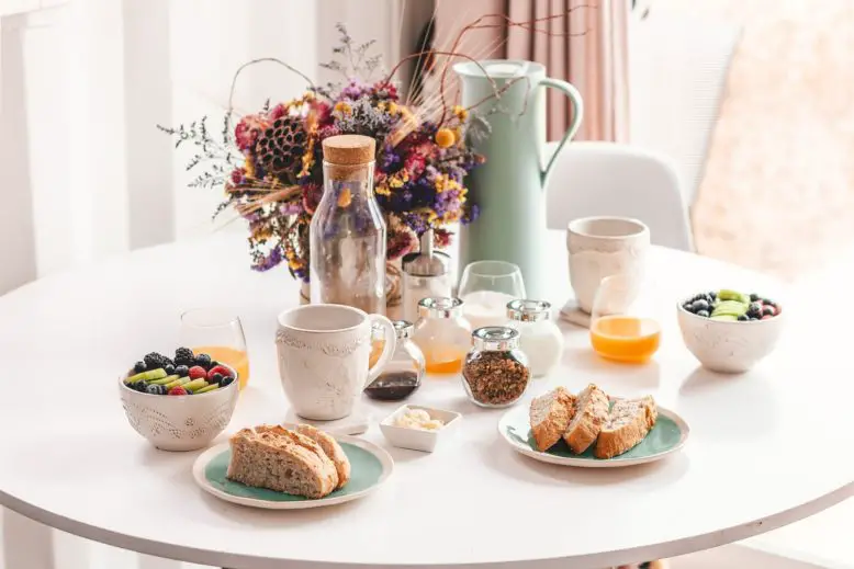 mesa redonda con bebidas y alimentos para desayunar