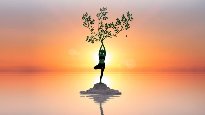 mujer en posición de yoga sostiene el árbol de la vida